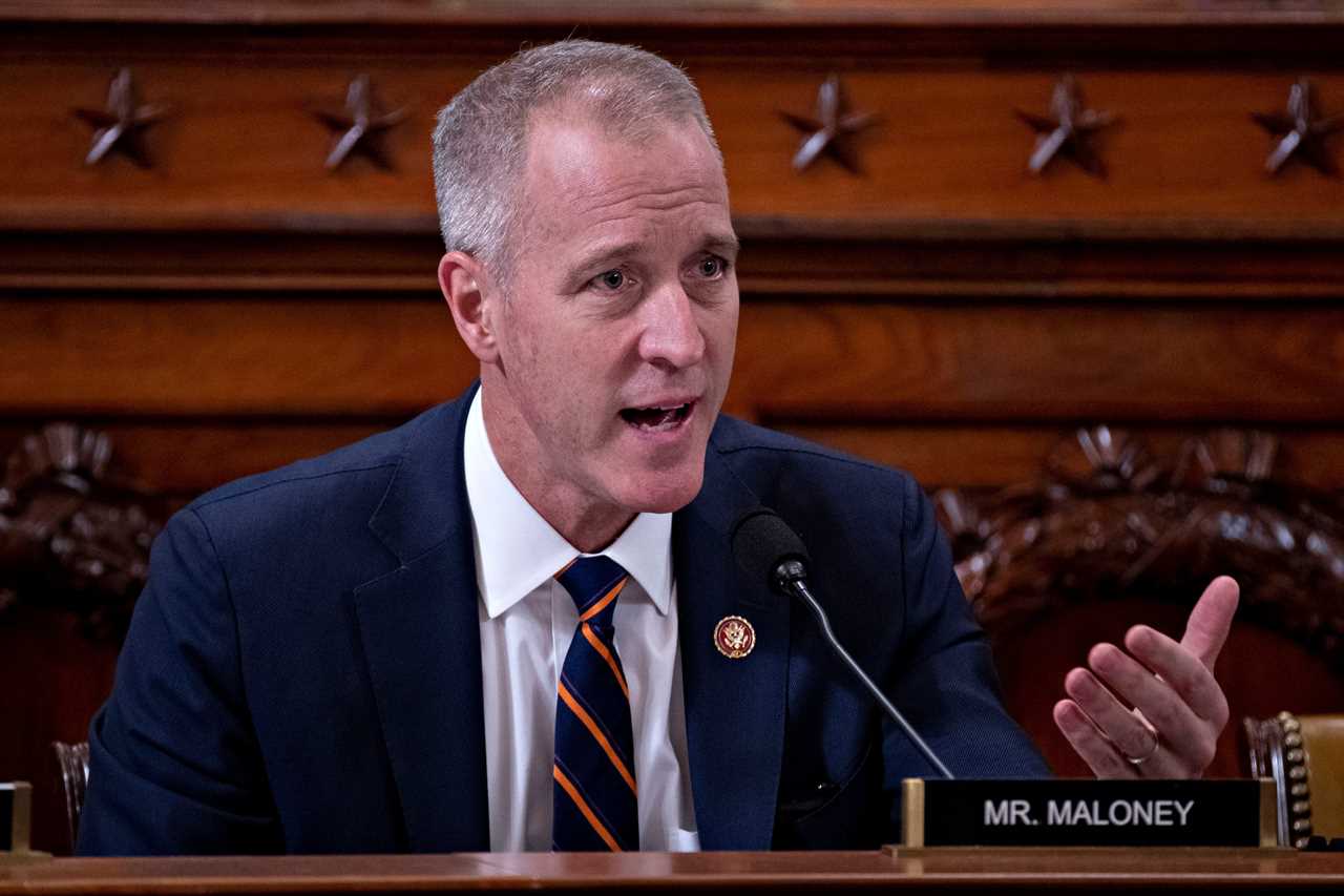 A politician sits behind a microphone on the floor of Congress.