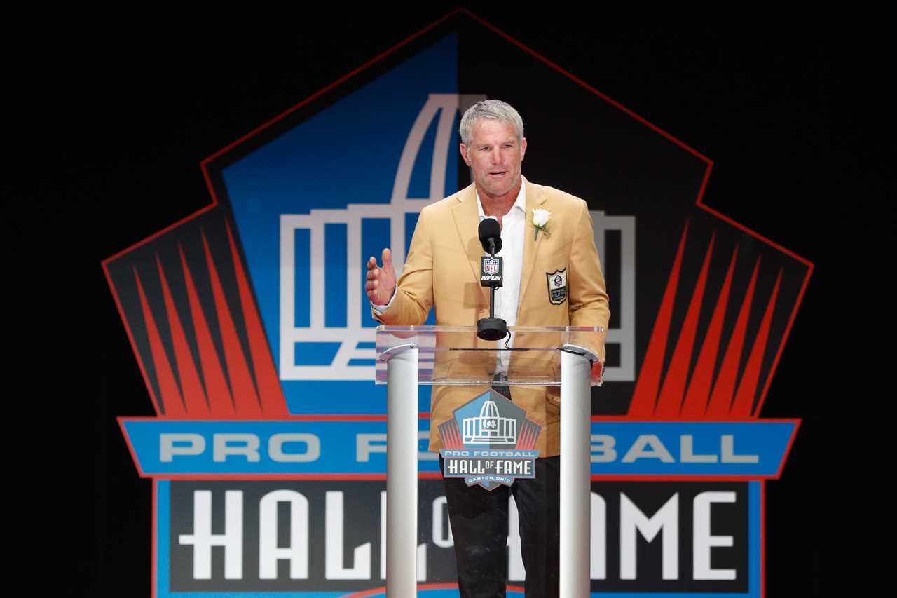 A man on a stage with "Wall of Fame" written behind him.