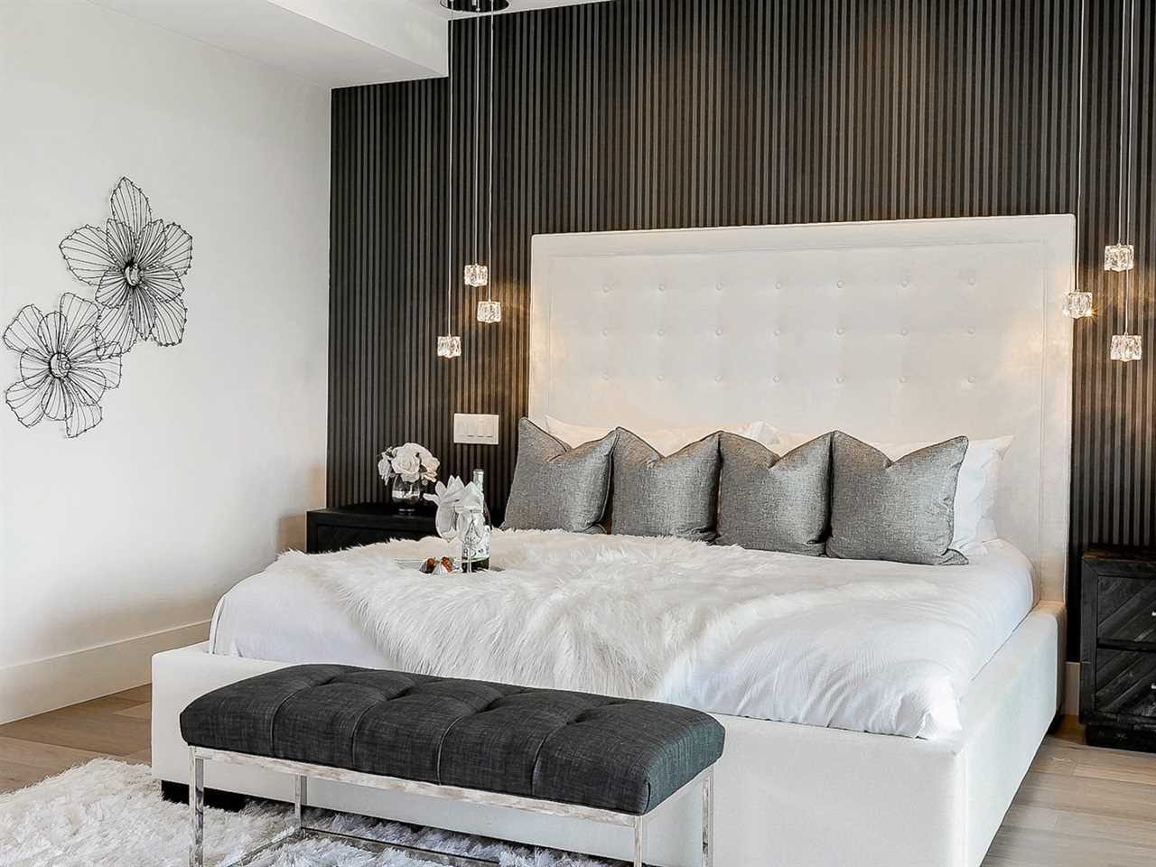 Bed with white sheets and dark brown accent wall behind it