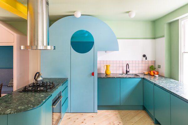 The curved blue kitchen larder has a projecting 