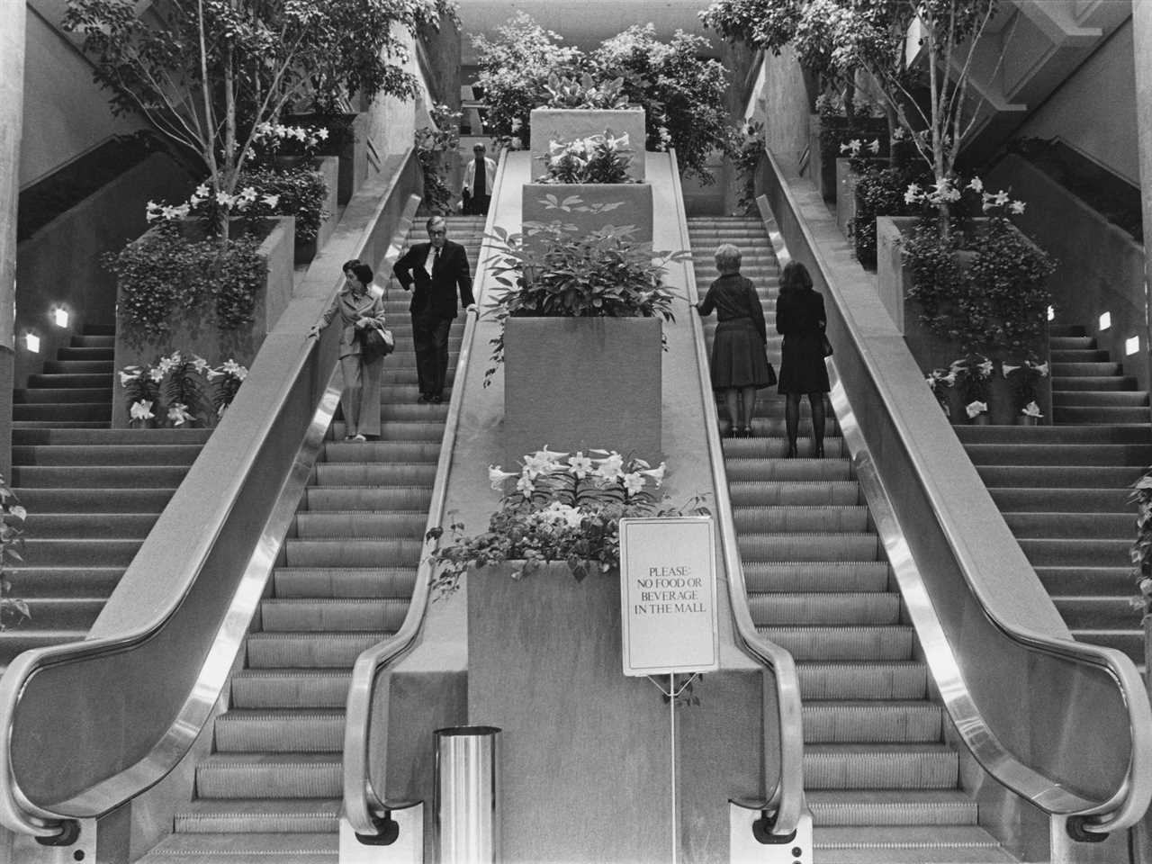 Shoppers ride escalators inside shopping mall in Chicago in the 1970s