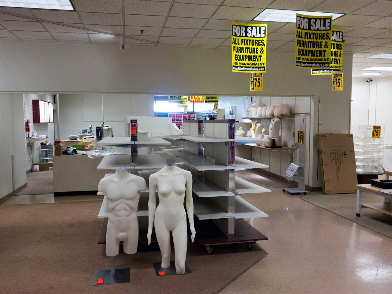 Empty shopping racks and mannequins at JCPenney store liquidation