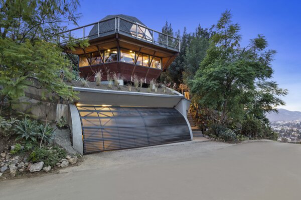 This home features plenty of spaces for outdoor entertaining, including a wraparound deck and a dining area tucked away amidst trees and native landscaping.