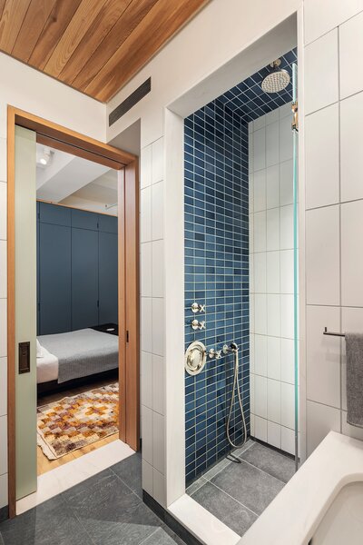 Blue tiles in the bathroom match the cobalt blue cabinetry made from reclaimed ash.