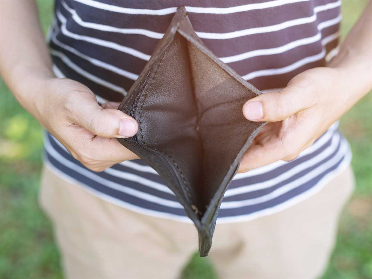 A young man holding an empty wallet