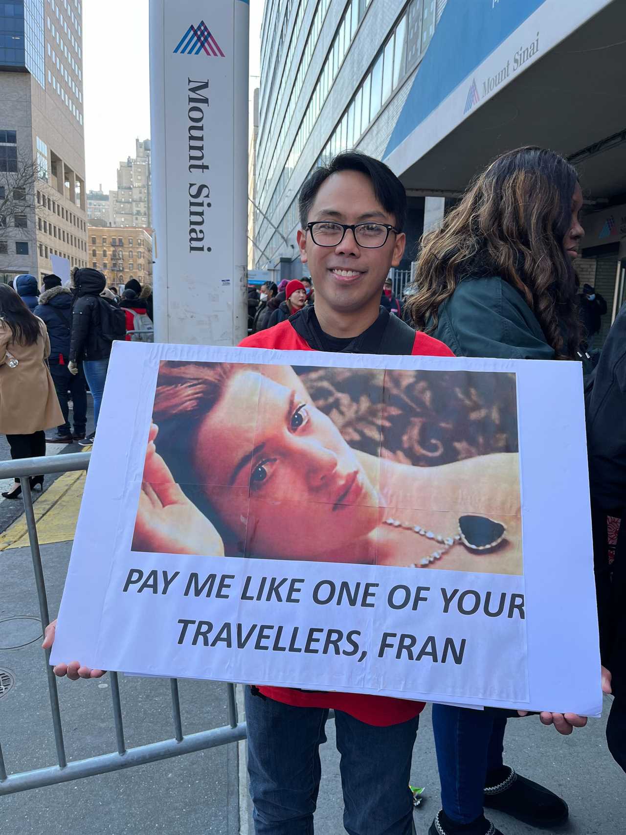 Philipp Carabuena holds a sign referring to travel nurses