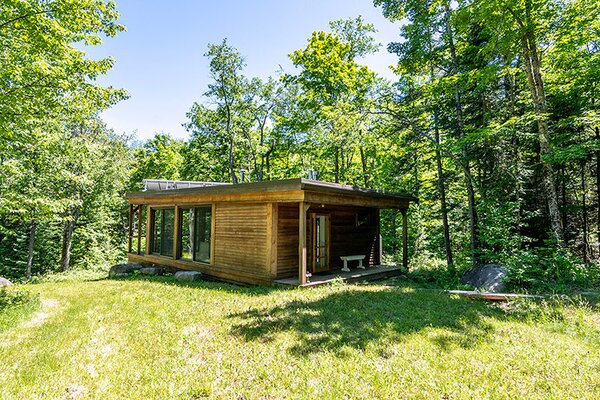 The one-level home is enveloped by towering trees, lush greenery, and many hiking trials.