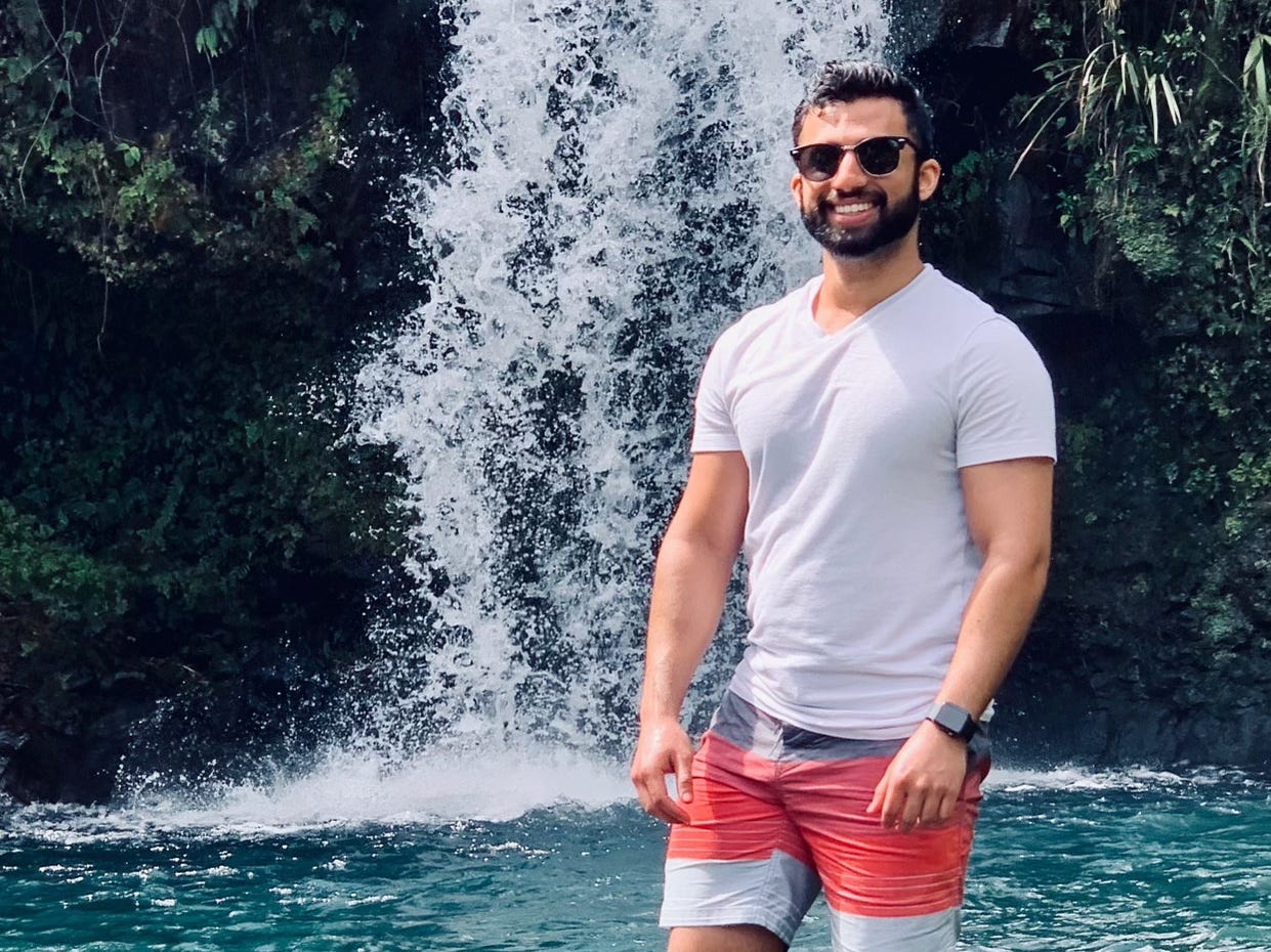 Qaleb Pillai pictured standing under a waterfall