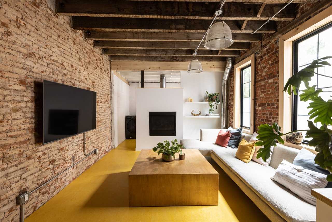 Yellow vinyl floor tile defines the new living room and keeps the interior from veering too industrial. 