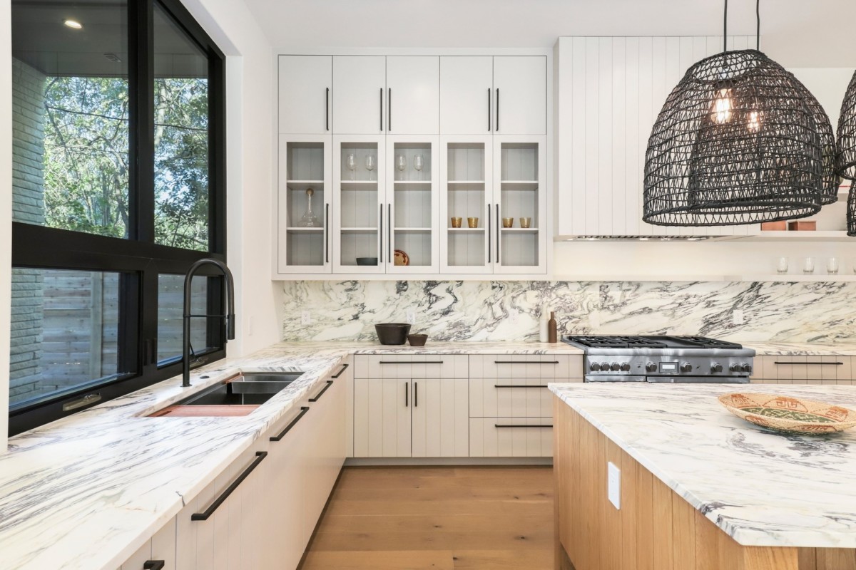 Beautifully updated kitchen with black hardware, white granite countertops and wood floors