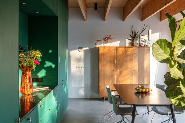 Inside, the living areas flow around a green box that contains the kitchen and a full bath.