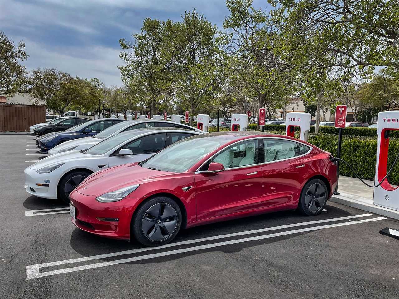 Tesla electric cars charge at a Supercharger.