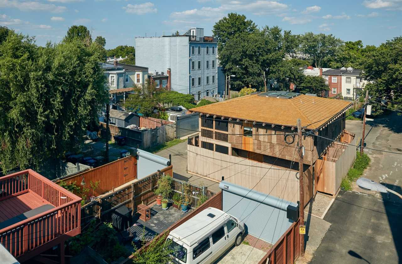 The Linns’ home, which Andrew Linn and Jack Becker completed for Andrew and his wife last year, declares its commitment to natural materials with a patchwork of wood products on its exterior. The sassafras cladding the lower portion of the house’s east face peels away from the building to become a freestanding fence enclosing a small, private outdoor space in the middle of the alley.