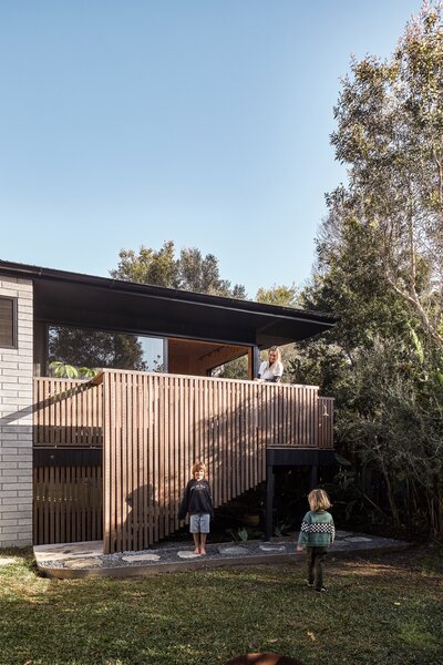 Flooding is a constant threat in subtropical New South Wales, so Casey Johnston (pictured, with sons Raph and Ozzy) and husband Martin asked architect Justin Twohill to design a backyard house that could weather a downpour with minimal cleanup.