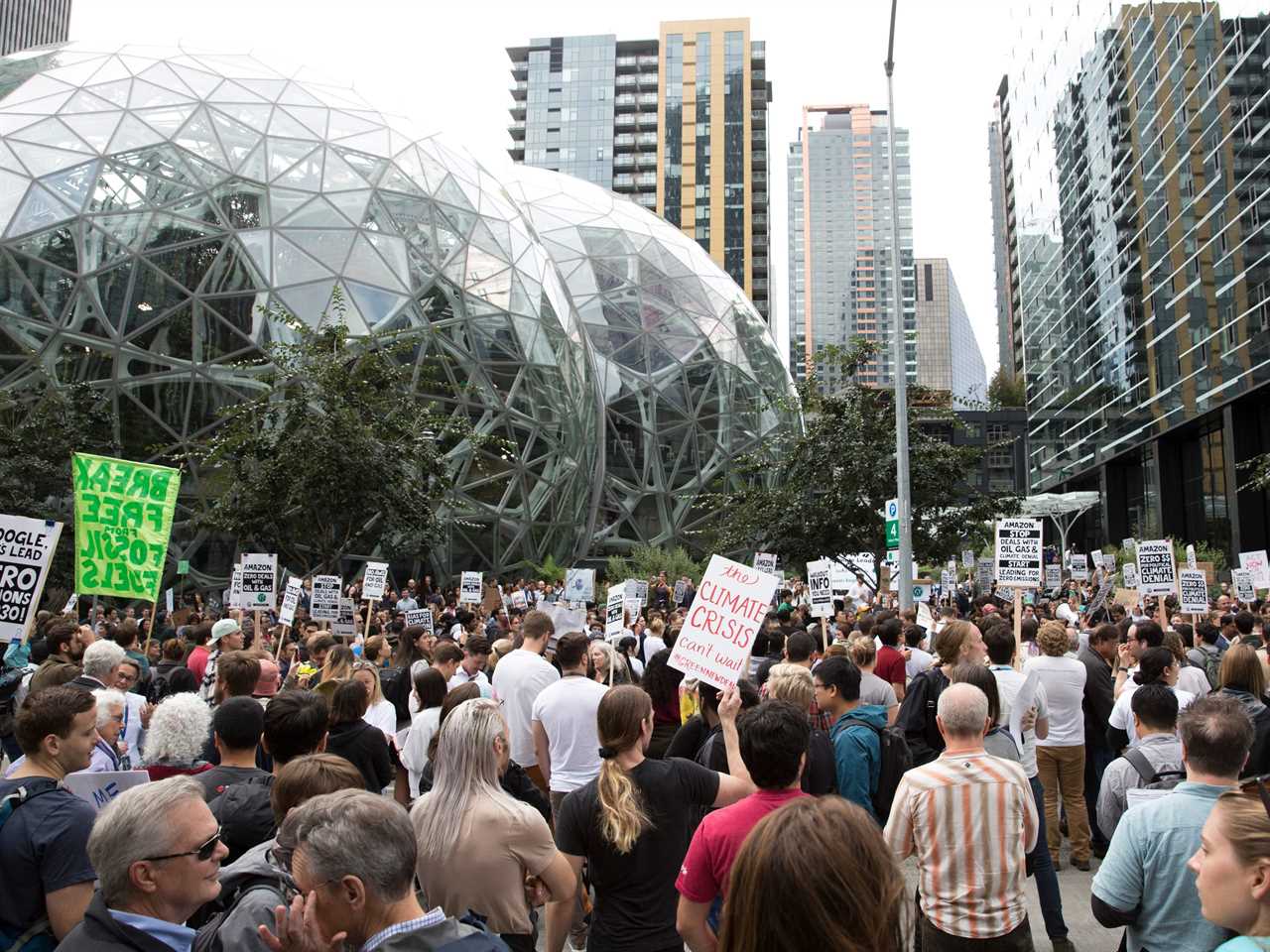 A large group of protesters with signs gather outside of Amazon's headquarters in Seattle.