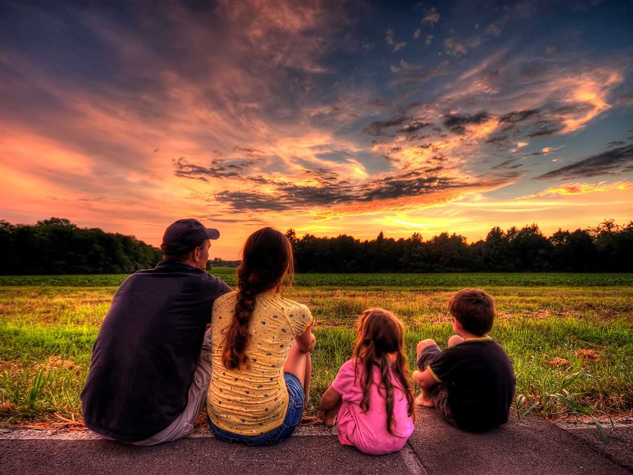 family of four sits on porch watching sunset in Murfreesboro, Tennessee