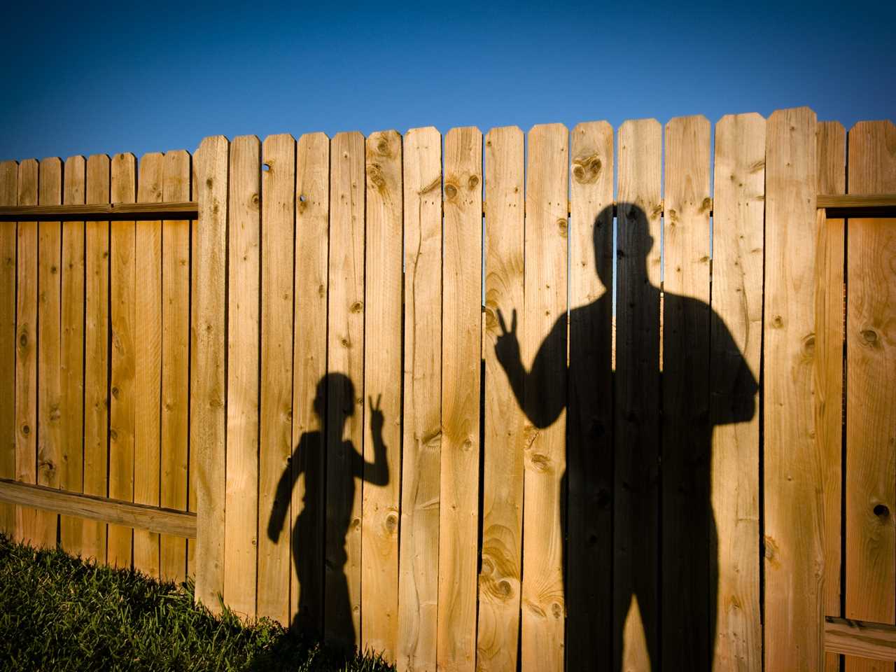 A father and daughter play with shadows in their backyard in Katy, Texas.