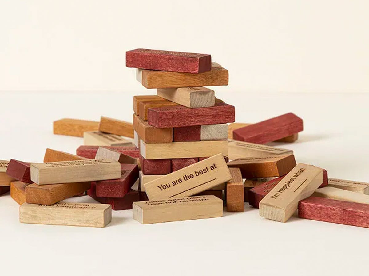 Pile of wooden blocks from the Falling for You Personalized Couple's Game, with a fill-in the blank block that says "You are the best at __"