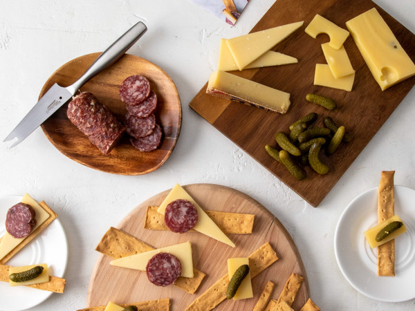 Three wooden cutting boards featuring an assortment of meats, crackers and cheeses from Murray's Cheese Perfect Pair.