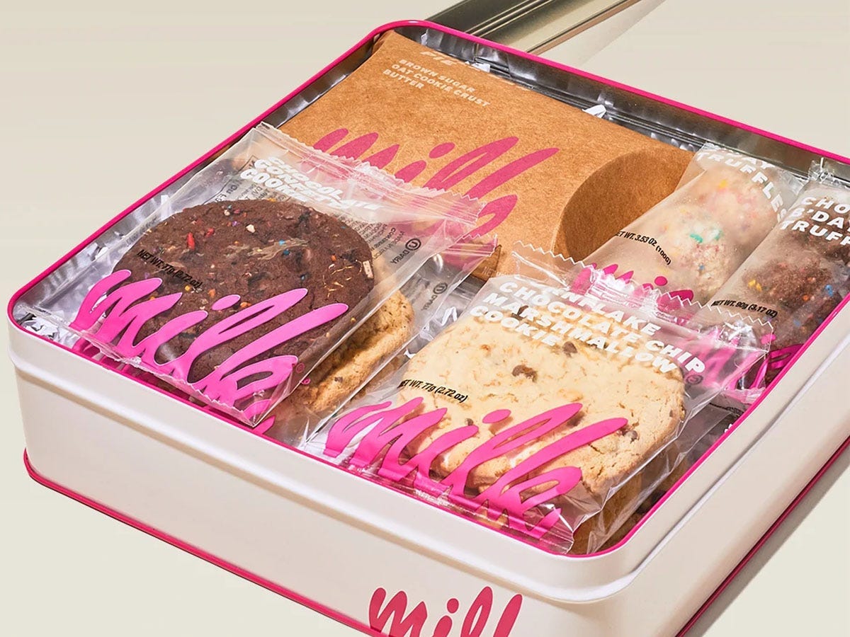 A tin box full of individually packaged cookies and truffles from Milk Bar.