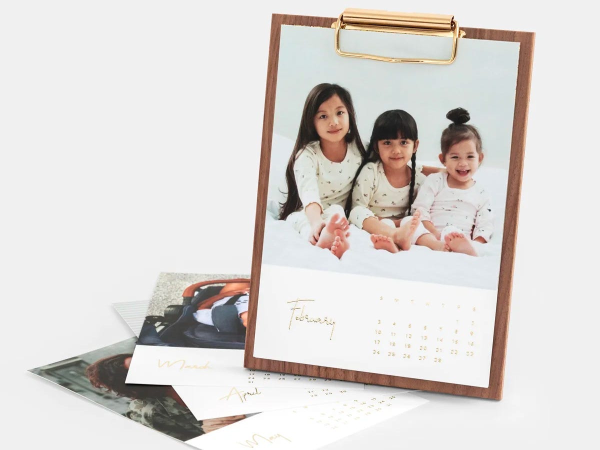 A walnut desktop photo calendar featuring an image of kids modeling matching pajamas.