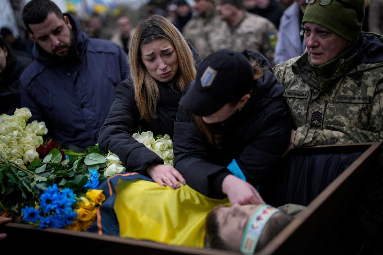 Widow Anastasia Ohrimenk mourns over the body of her fiance Oleksiy Zavadskyi, a Ukrainian serviceman who died in combat on January 15 in Bakhmut during his funeral in Bucha, Ukraine, on January 19, 2023.