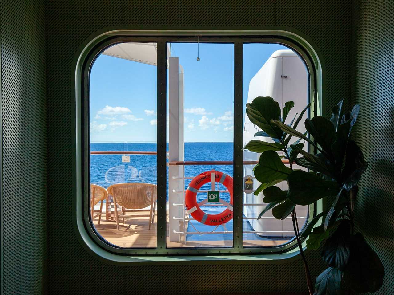 a window looking out onto the walkway and ocean