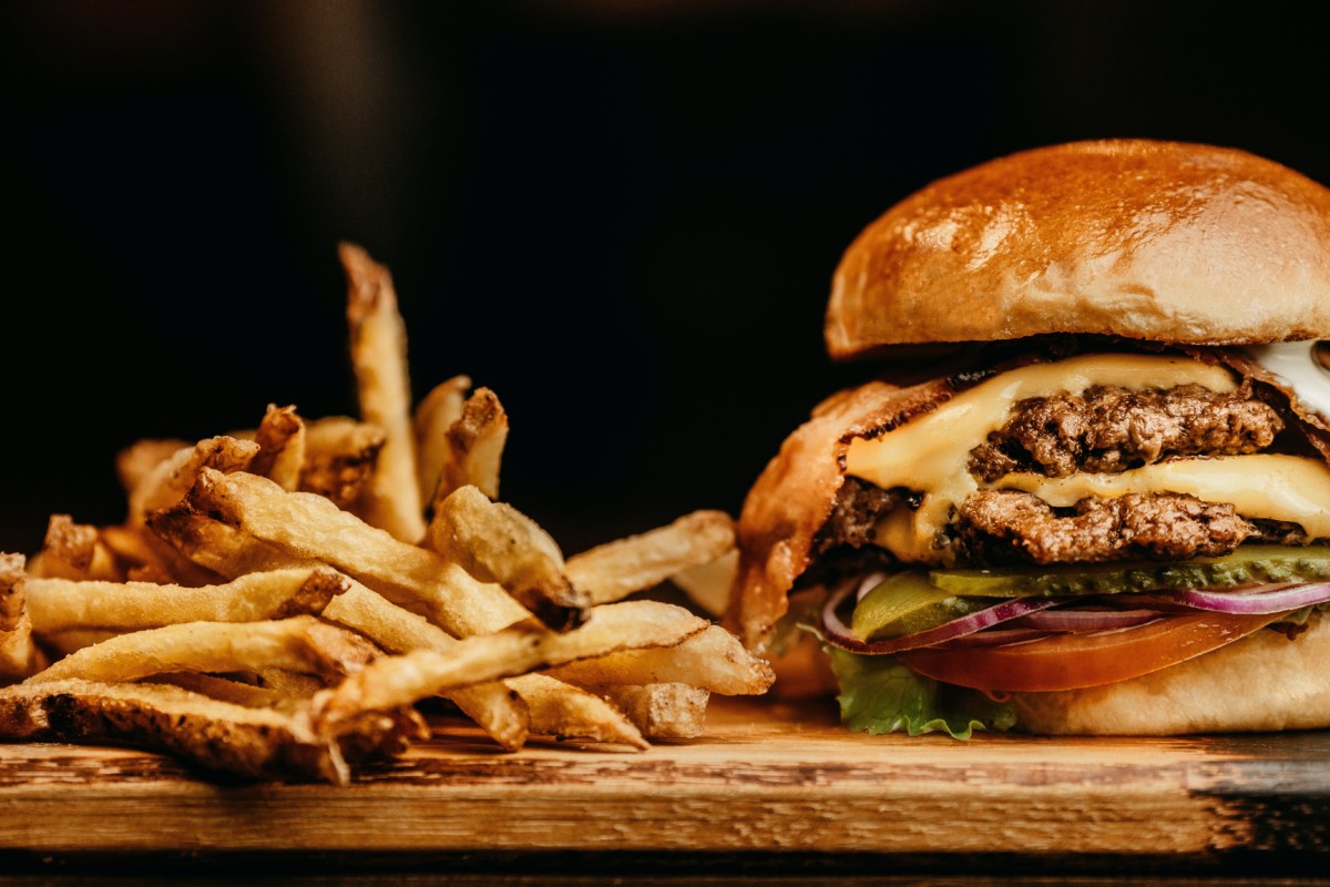 bacon burger and fries on a block