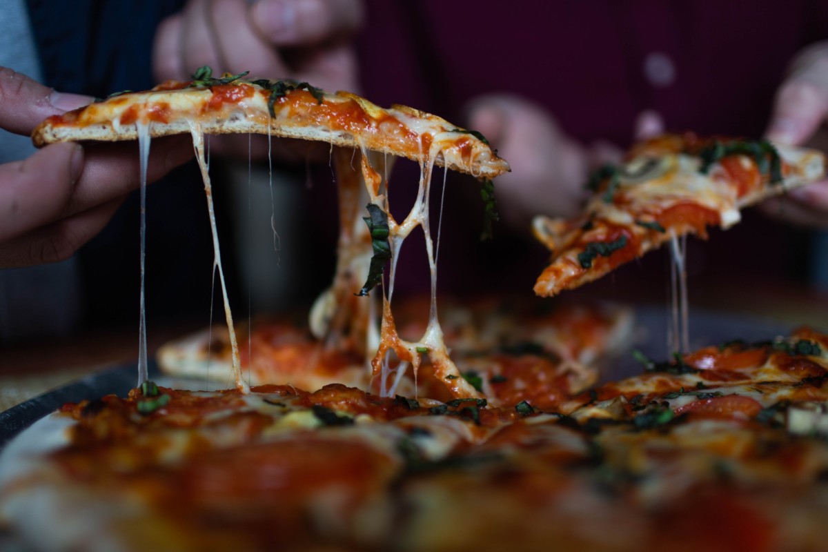 people eating pizza with tomato sauce basil and cheese