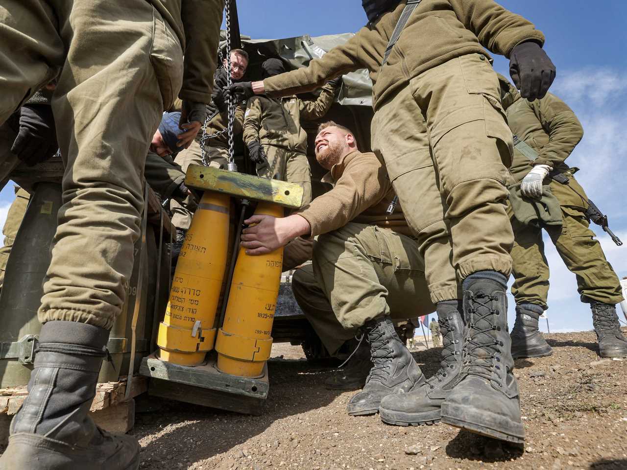 Israeli soldiers transport munitions off a vehicle at a position in the Israeli-annexed Golan Heights on January 2, 2023.