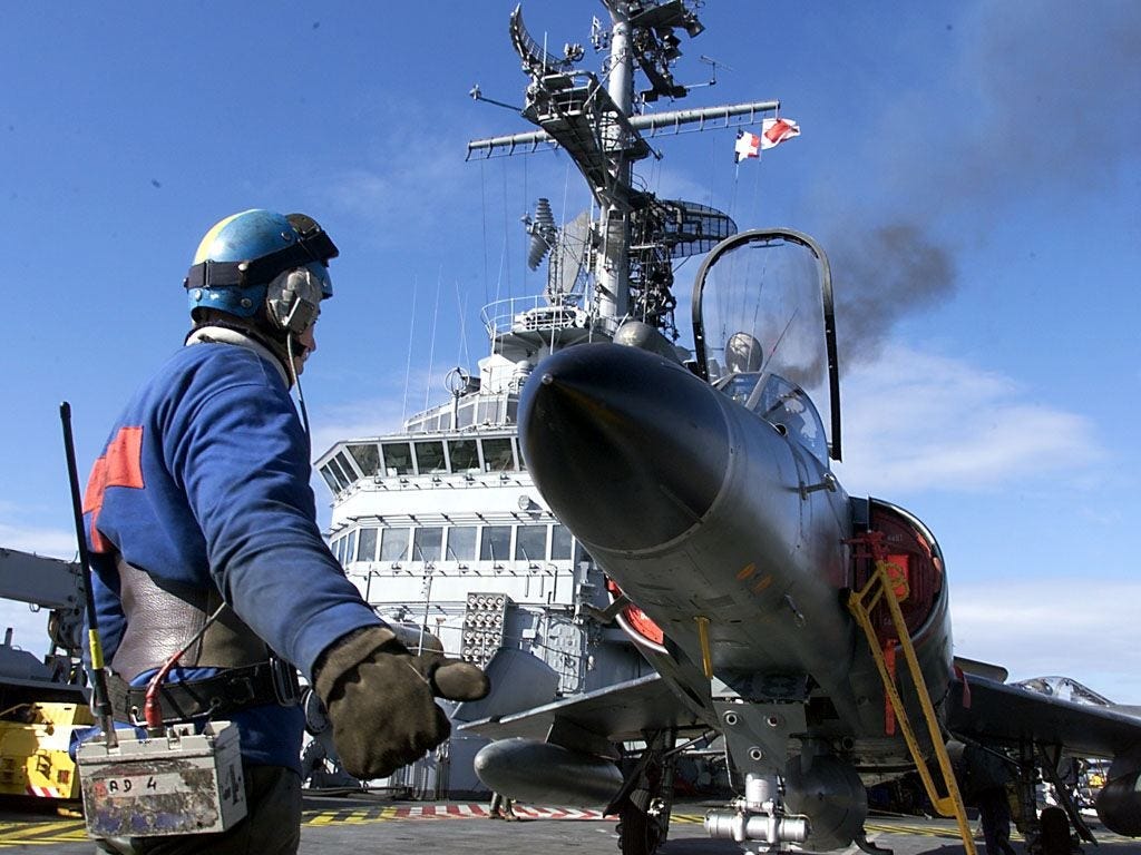 A personnel member guides a Super Etendard 4P reconnaissance plane before its lift-off from the French aircraft carrier 'Foch' in the Adriatic sea on 4 February.