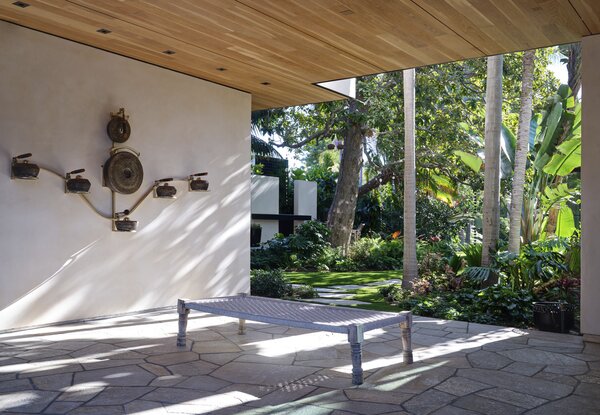 On the covered terrace, homeowner Gillian Wynn paired a daybed made of recycled plastic with a gamelatron sculpture by Aaron Taylor Kuffner.