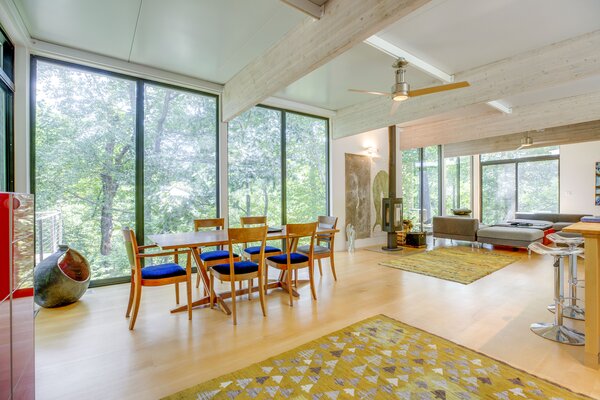 Inside, expansive, floor-to-ceiling windows wrap around the main living spaces.