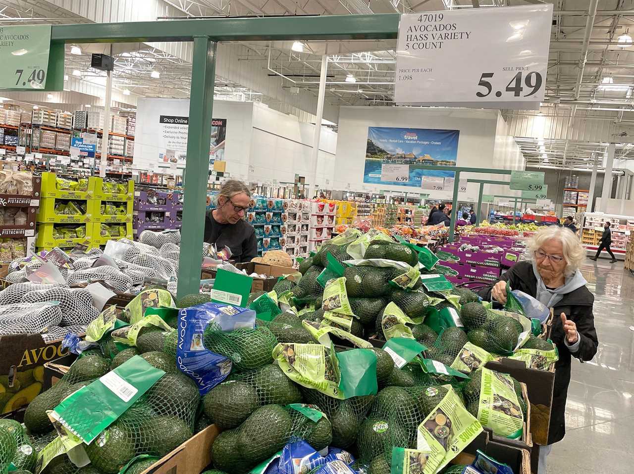 People looking at avocados in a store