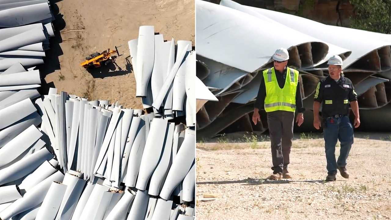 A bulldozer drives amid a pile of wind turbine pieces, which are piled on sandy ground