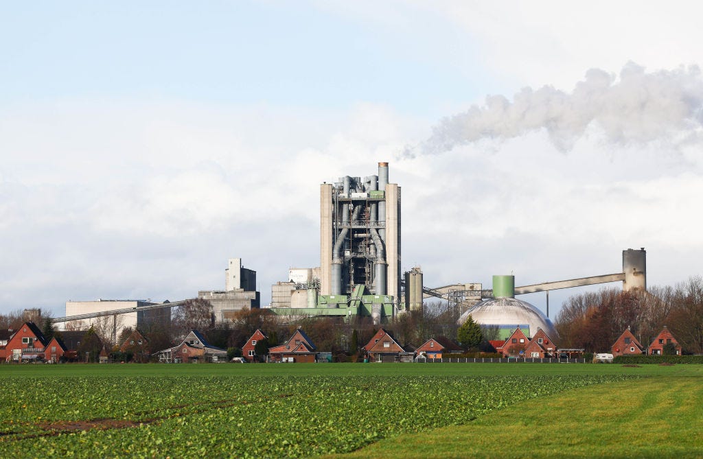 A factory emits a plume of emissions near a row of houses.