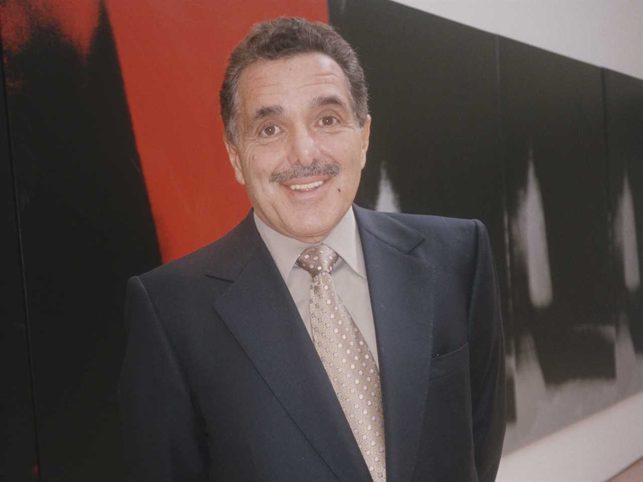 Leonard Riggio stands smiling in front of large artwork at a museum