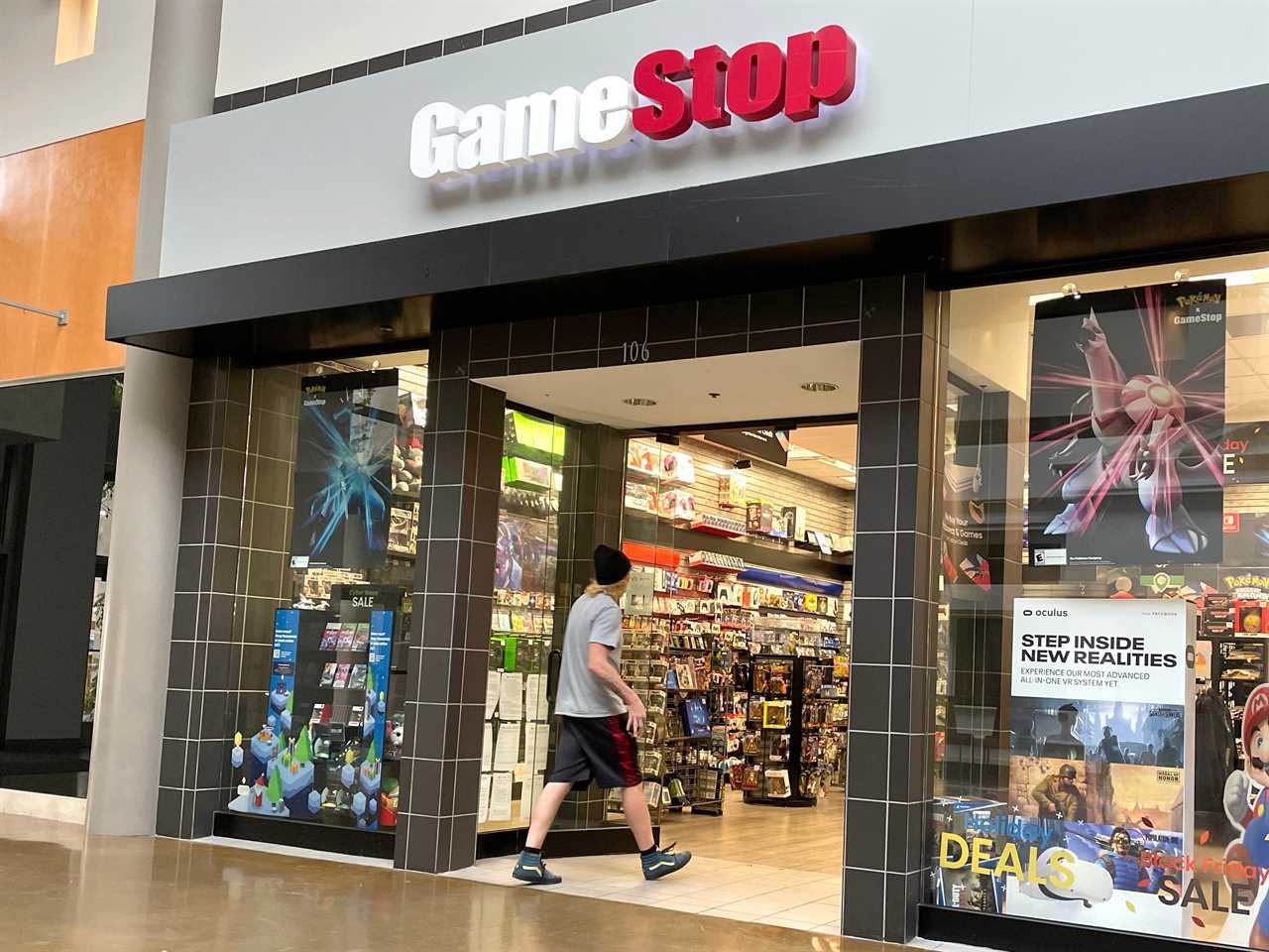 A young man walks into a GameStop video game store.