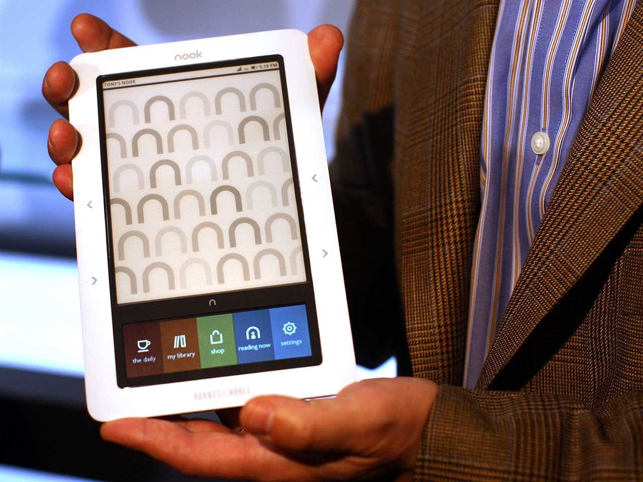 Hands hold the Nook e-reader displaying it at launch event