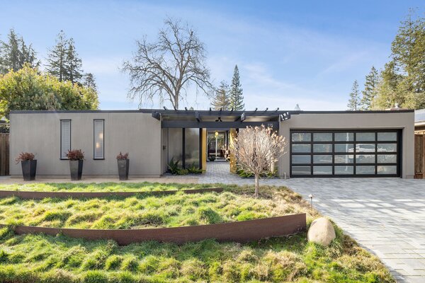 Upon arrival, bright yellow doors lead to the home's open-air atrium, which presents access to various rooms across the single-level, H-shaped floor plan.