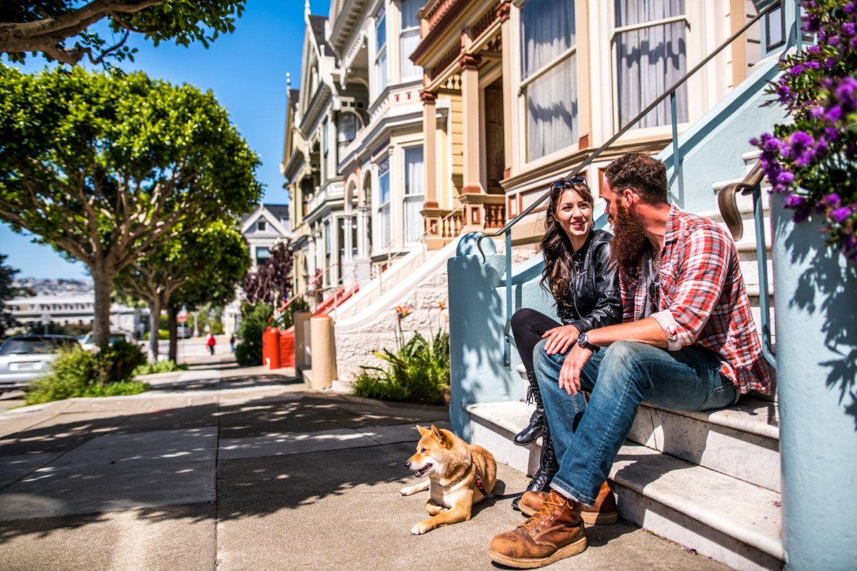 A couple sitting and talking outside their townhouse