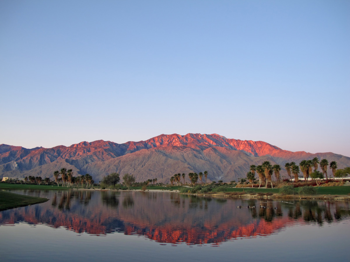 Golf course at dawn with sunrise kissed mountains _ getty