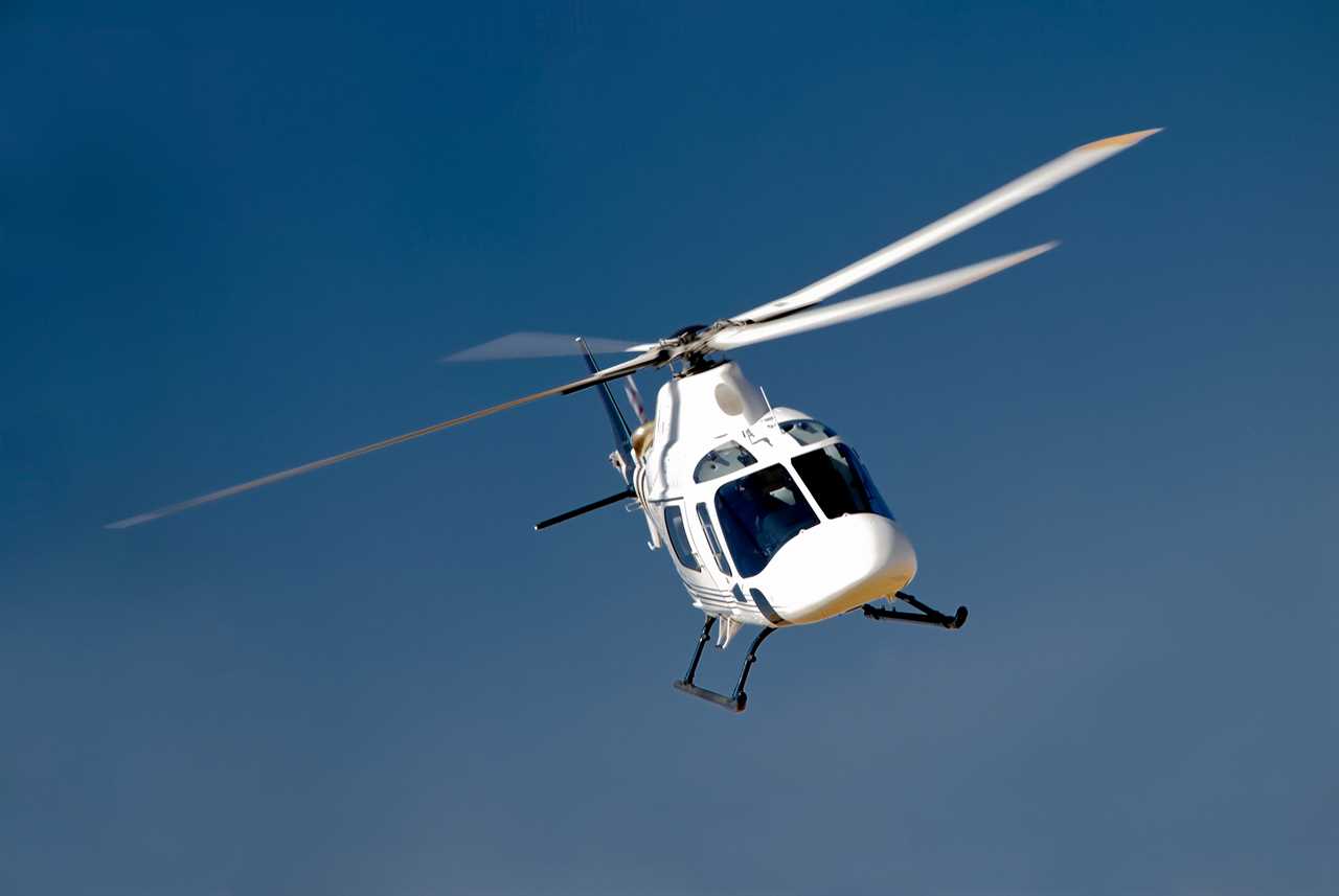 A white, tourist helicopter flying through the sky