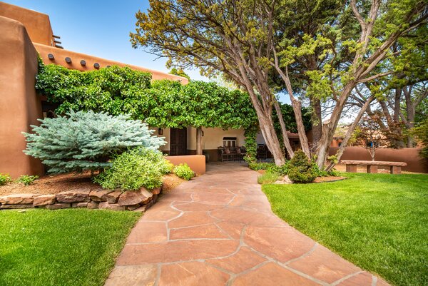 Located three miles outside of Santa Fe, the sprawling estate offers a convenient desert escape, complete with thriving gardens, lush landscaping, and multiple shaded areas.