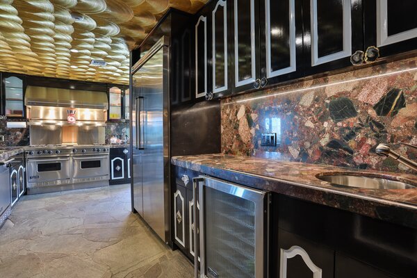 The wrap-around kitchen features a shimmering ceiling and two-toned cabinetry.