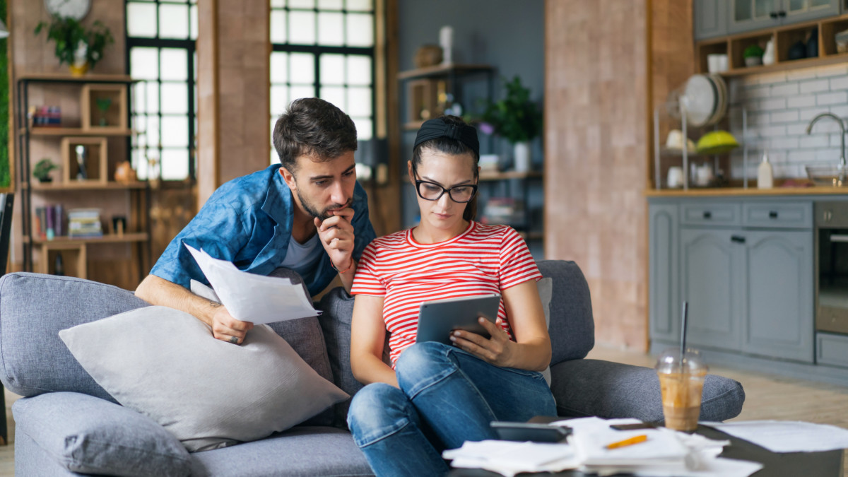 Couple in living room determining their budget to buy a house