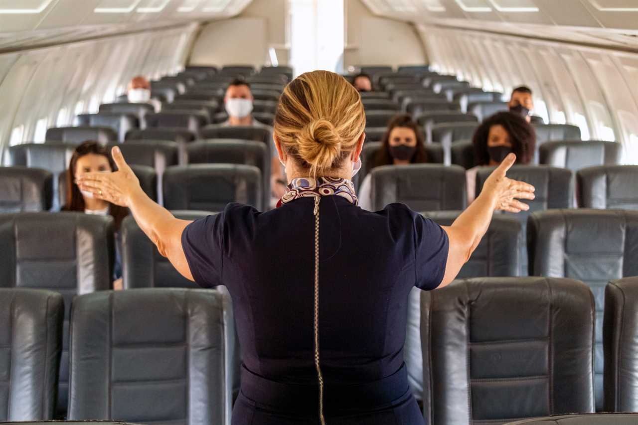 A flight attendant addressing passengers.