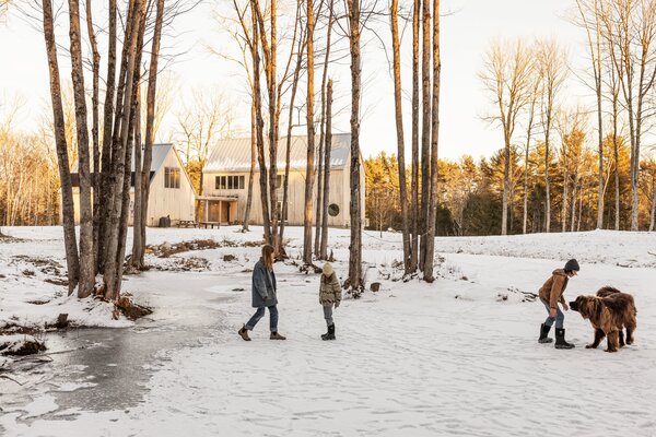 Josh and Natalie Pritchard’s residence in the woods of New Gloucester, Maine, consists of two parallel gable structures connected by a breezeway. The taller building is the home, and the shorter is a two-car garage with an in-law apartment. The Pritchard children call the wetlands behind the house 