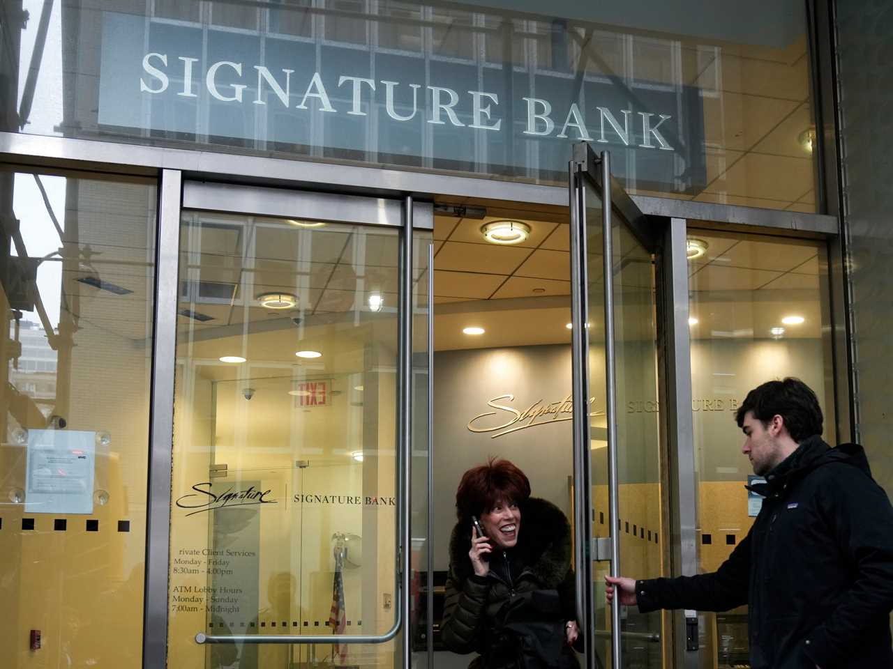 A woman leaves a branch of Signature Bank in New York, Monday, March 13, 2023.