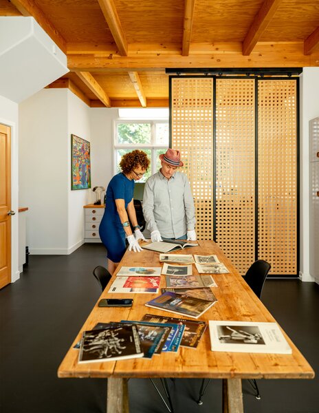 Tama and Lauren Bell renovated a three-story condo in Sebastopol, California, where Judy Tyrus and Eric Waldman could live and run their non-profit. In the ground-floor office, sliding panels made by Lattice Stix separate two desks from a larger work space.